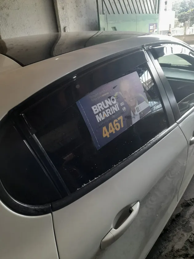 Adesivo aplicado no vidro lateral de um carro prata