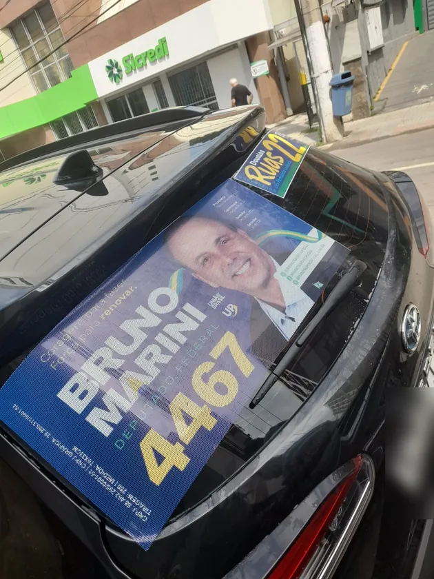 Adesivo no vidro traseiro de um carro preto