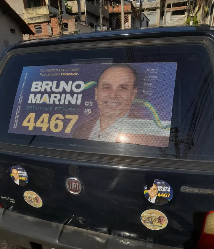 Adesivo grande e selos redondos na traseira de um Fiat Uno azul